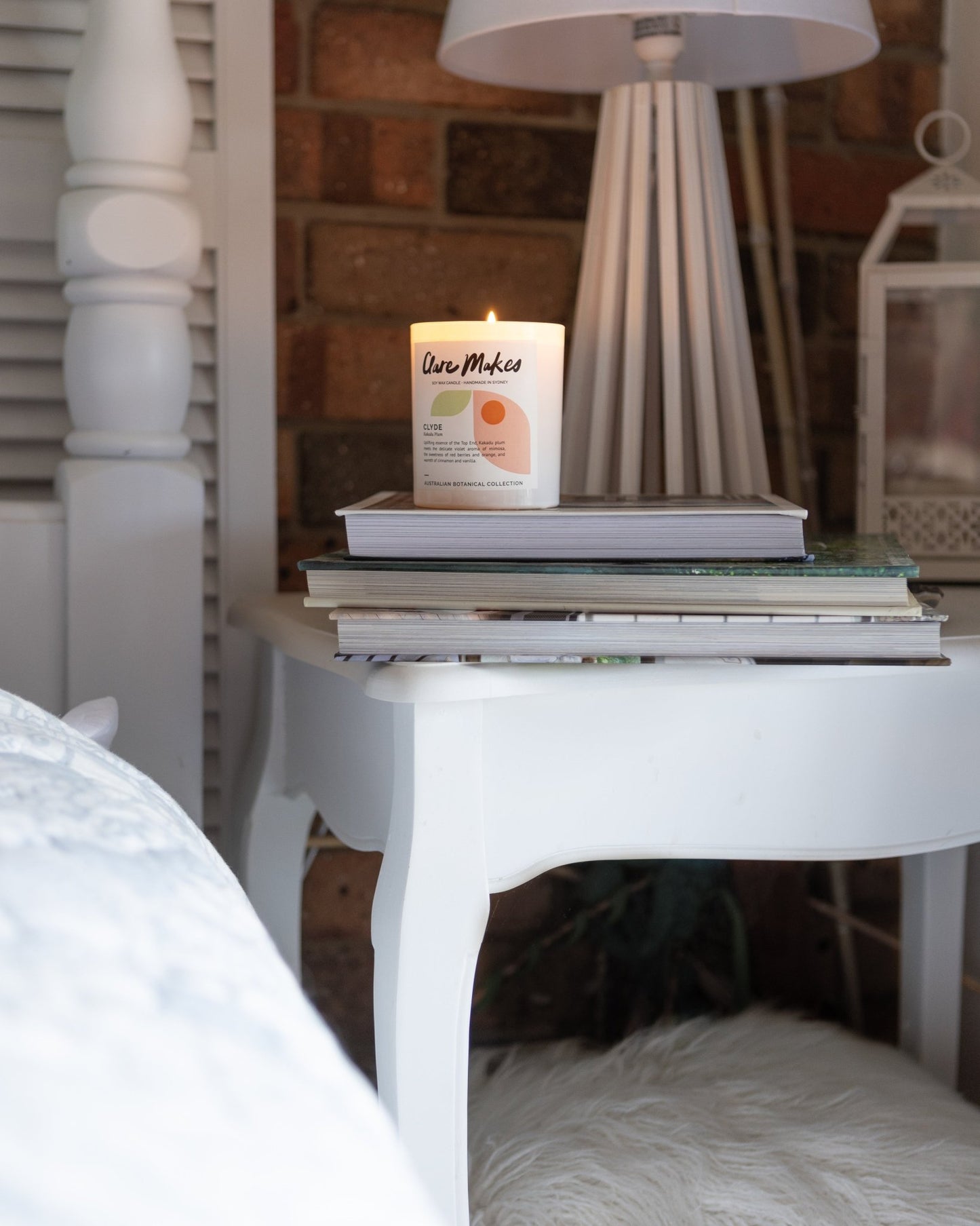 Clare Makes Kakadu Plum candle on bedside table with soft morning light