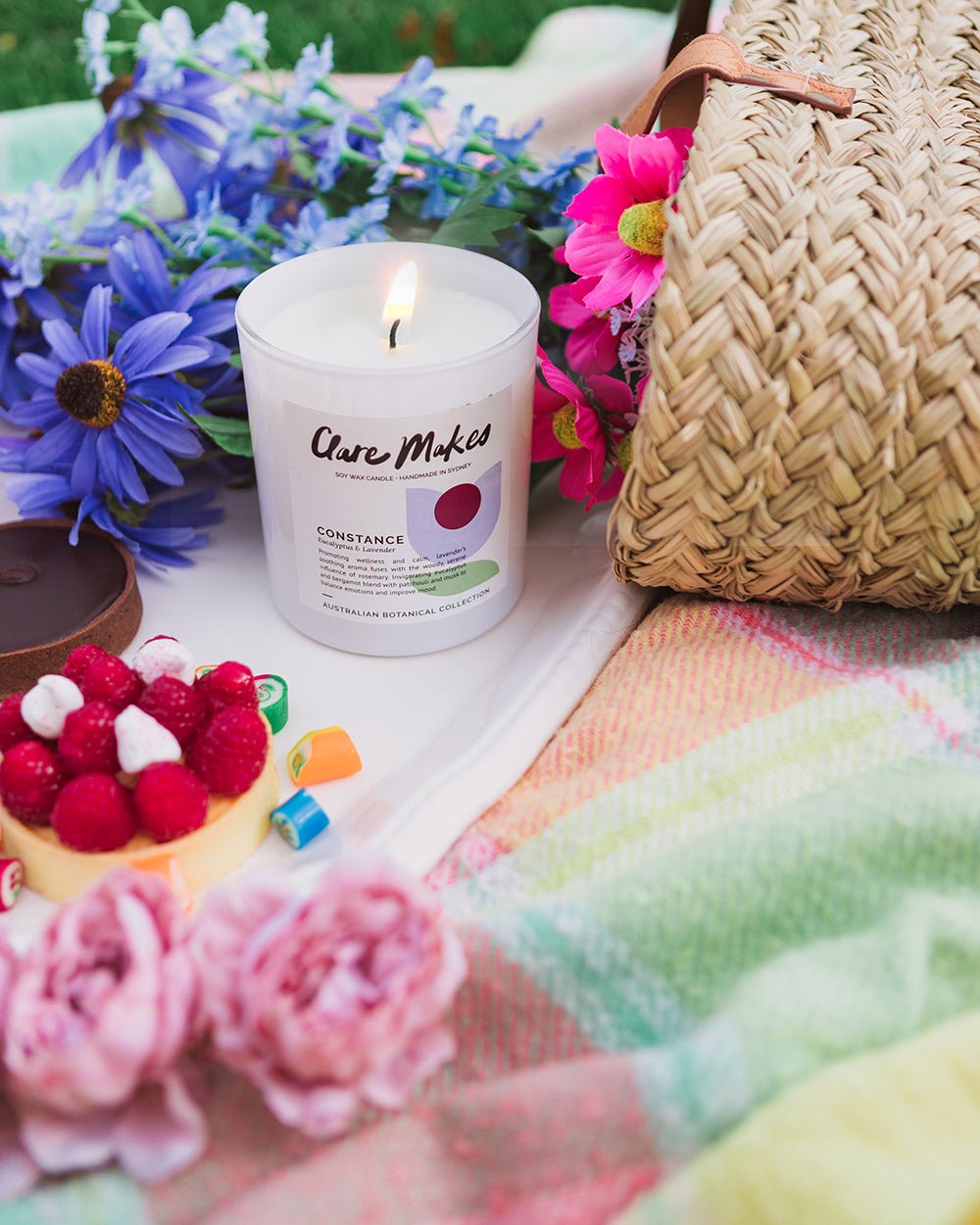 Styled image of Constance: Eucalyptus & Lavender candle on a picnic blanket with soft light