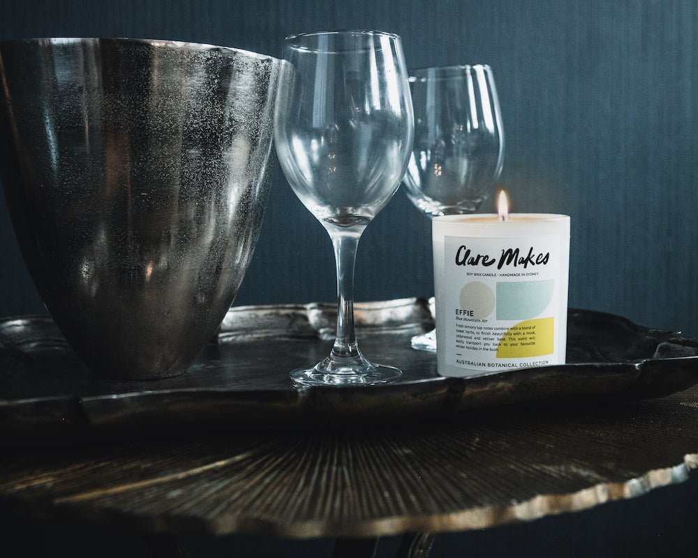Effie: Blue Mountain Air candle in a dark, moody winter setting with crystal glassware