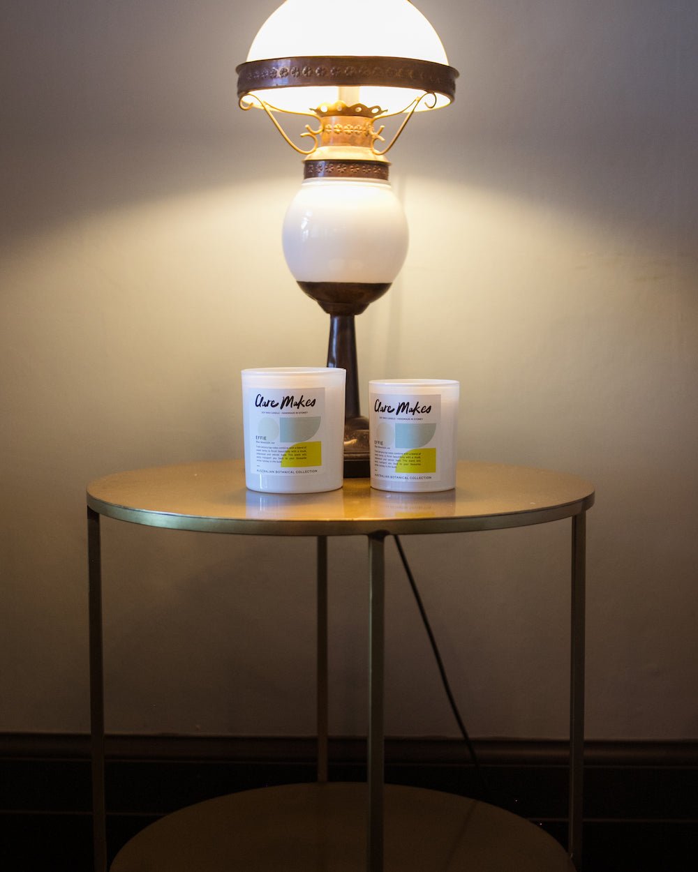 Effie: Blue Mountain Air candle on timber table with moody lamp glow