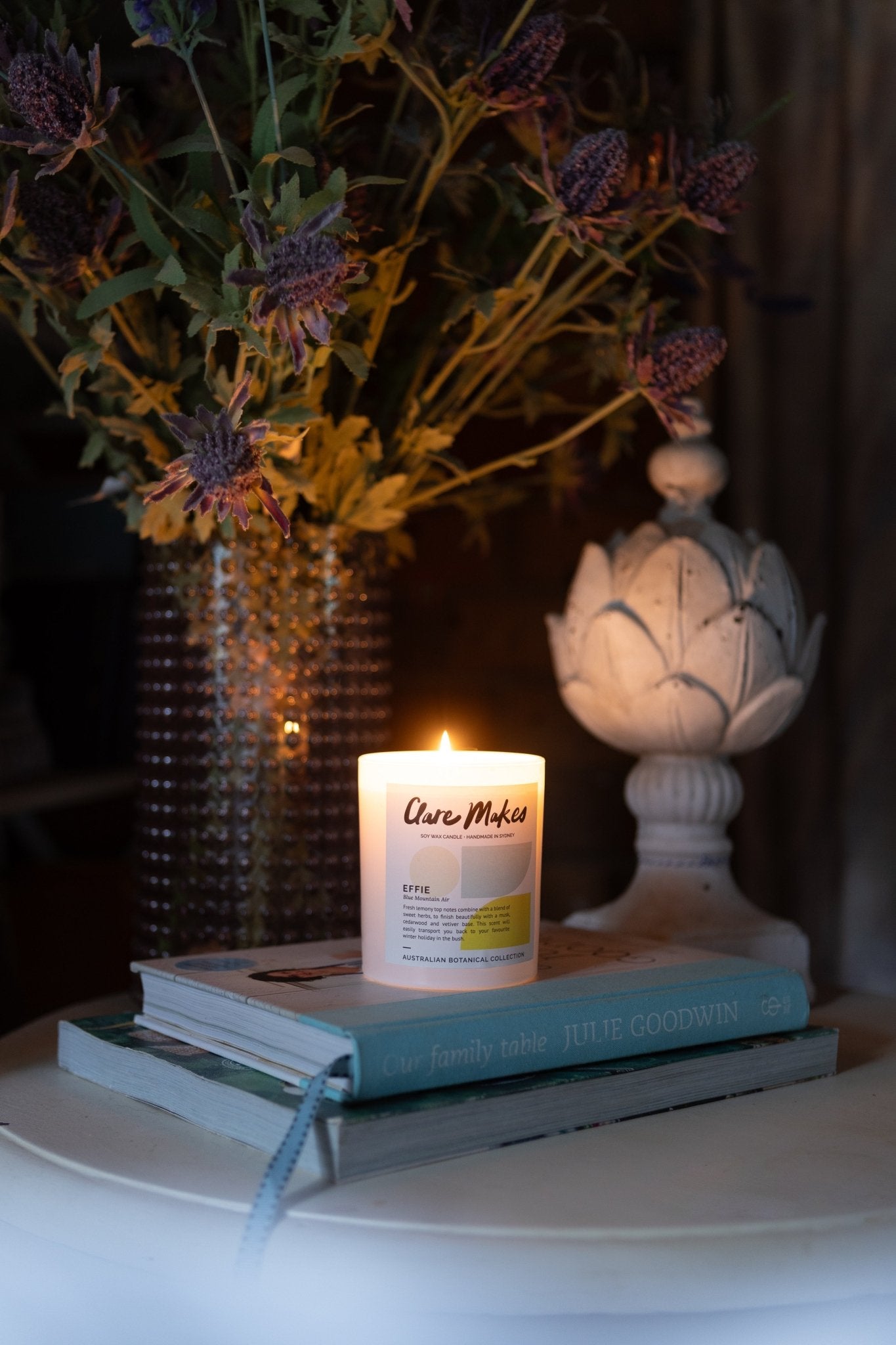Effie: Blue Mountain Air candle glowing beside native flowers and ceramic pieces