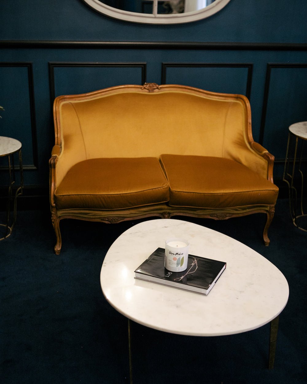 Ellis: Ghost Gum Breeze candle by Clare Makes on a white marble table with yellow velvet chair.