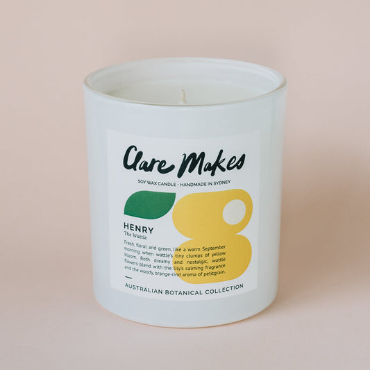 Clare Makes Henry: The Wattle candle, close-up against soft pink background showcasing product label