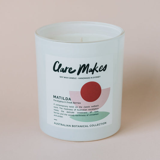 Matilda eucalyptus and berries candle by Clare Makes in white jar with green and red label