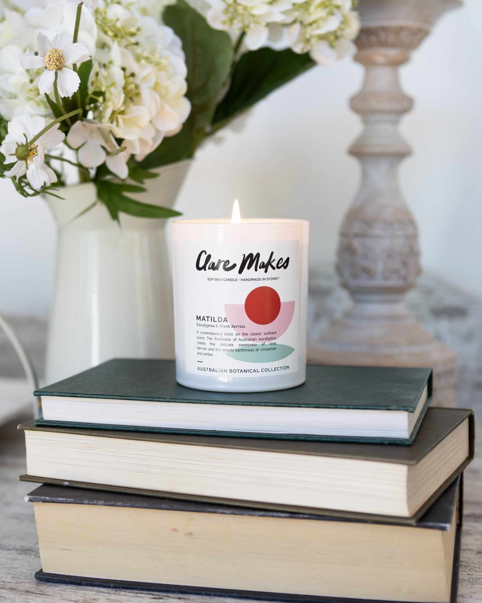 Matilda eucalyptus and berries candle by Clare Makes in white jar with green and red label