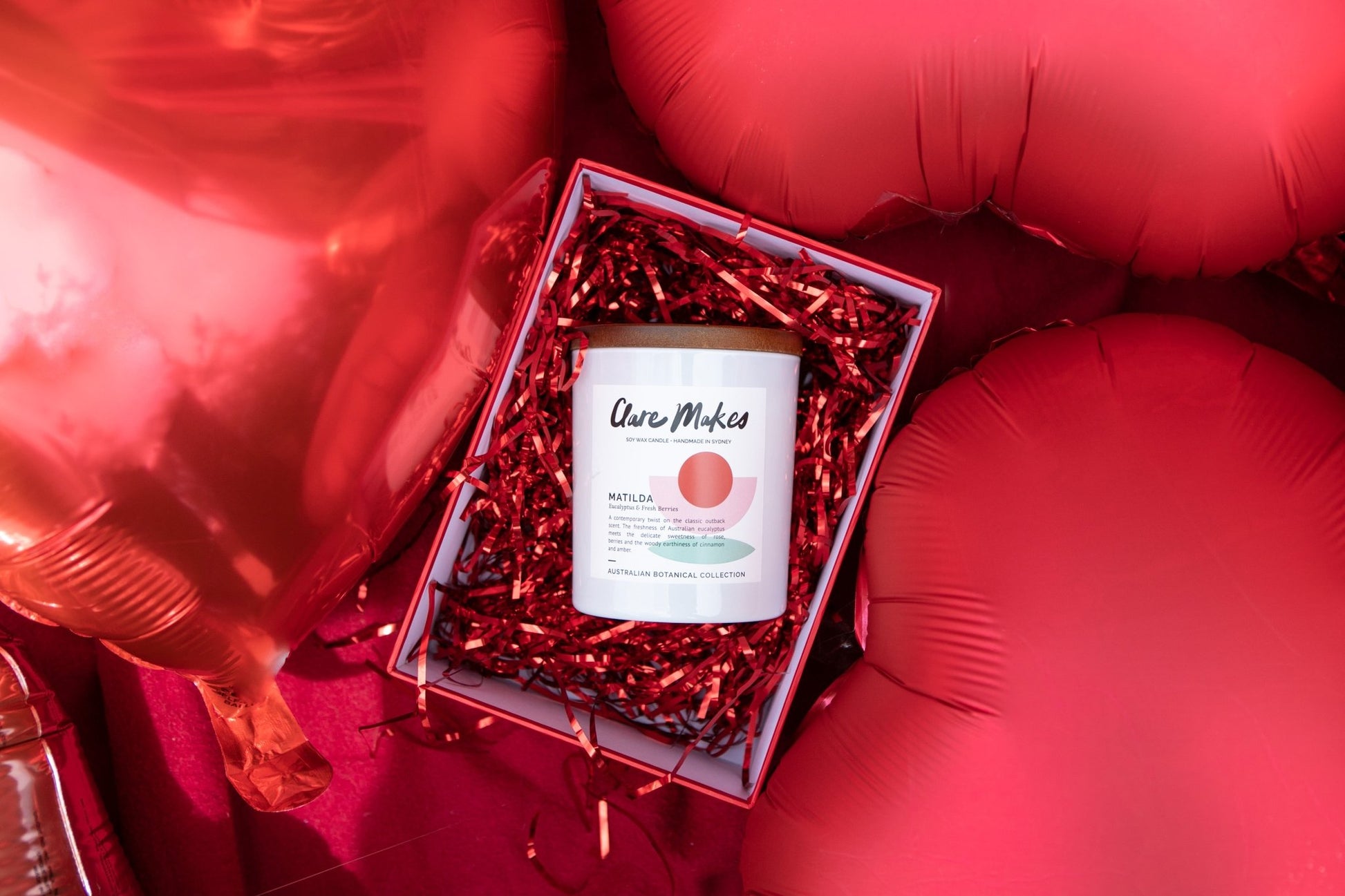 Matilda eucalyptus and berries candle by Clare Makes in white jar with green and red label