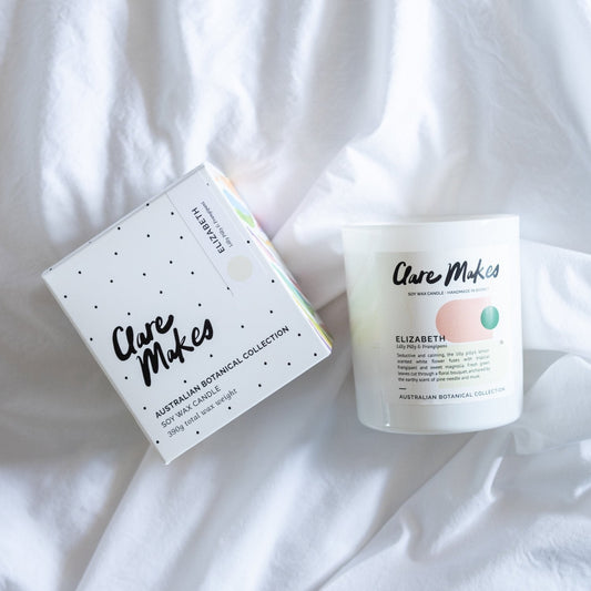 Elizabeth candle and sampler pack on white bedspread, Clare Makes