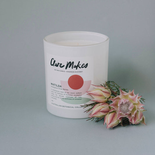 Clare Makes Matilda candle with pink flower accent and clean product styling